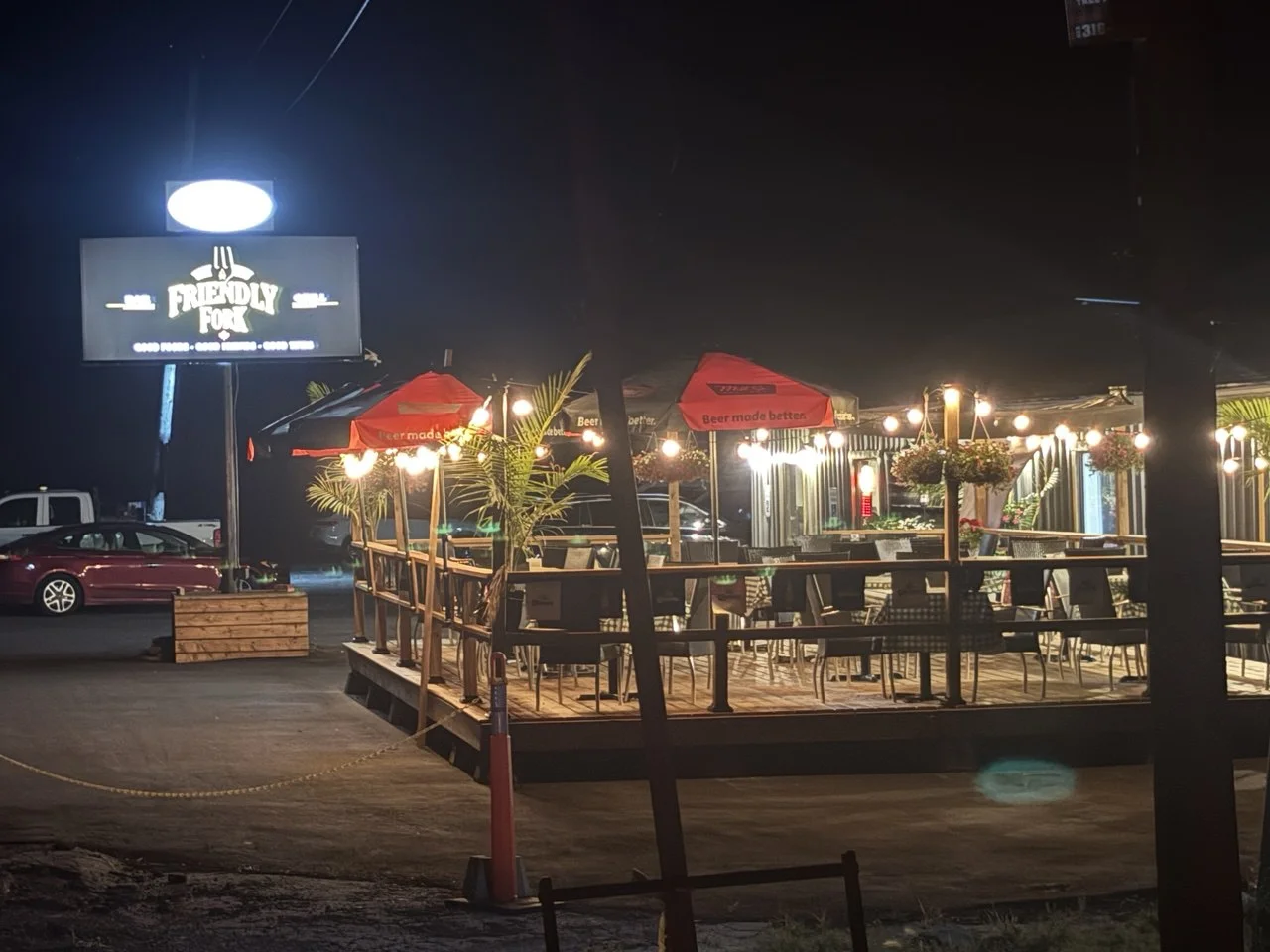 Friendly Fork patio at night with warm string lights and umbrellas